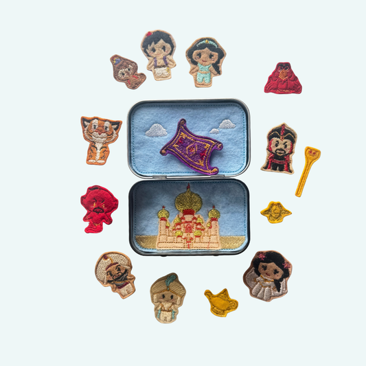 Collection of embroidered characters in a tin on a white background