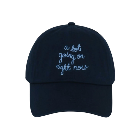 Navy blue cap with white text 'a lot going on right now' on a white background