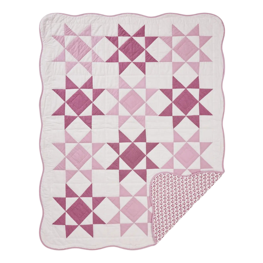 Pink and white quilt with diamond pattern on a white background
