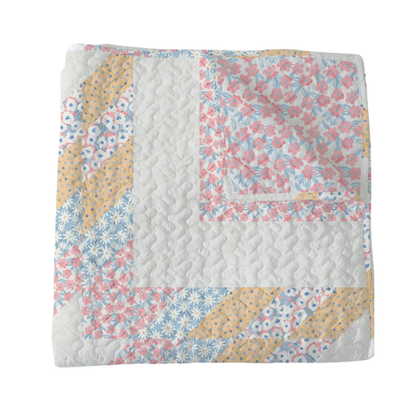 Floral quilt with a patchwork design on a white background
