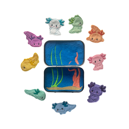 Set of colorful sea creature-themed patches around a tin with an underwater scene.