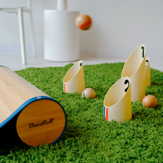 Game with wooden ramp, tunnels, and balls on a grass-like surface.