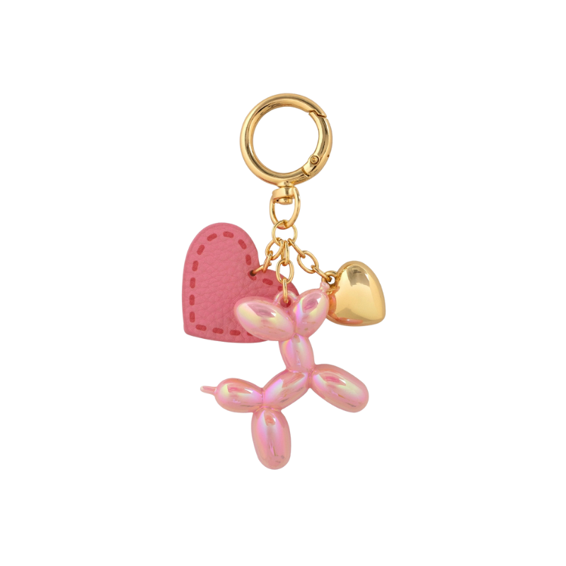 Pink balloon dog charm with a heart and gold accents on a white background