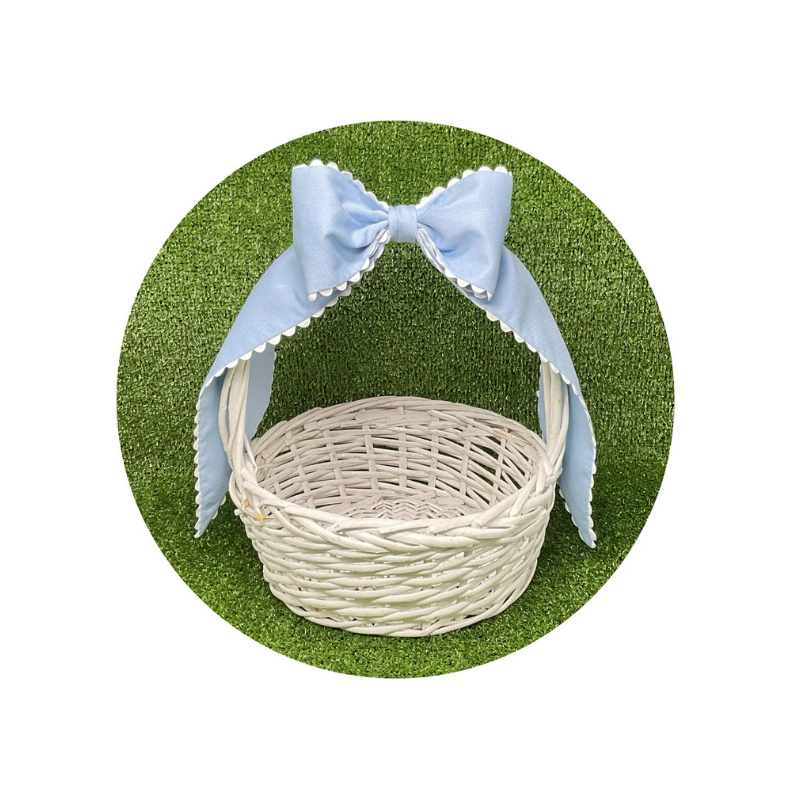 Wicker basket with a blue bow on a green background