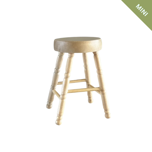 Wooden stool on a white background with 'MINI' label in green corner