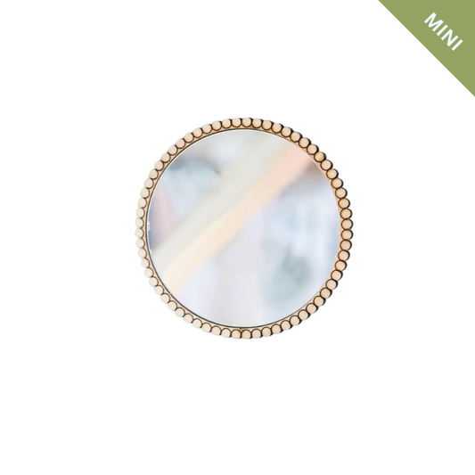 Round mirror with gold frame on a white background