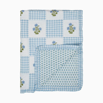 Baby blanket with blue checkered pattern and floral embroidery on a white background