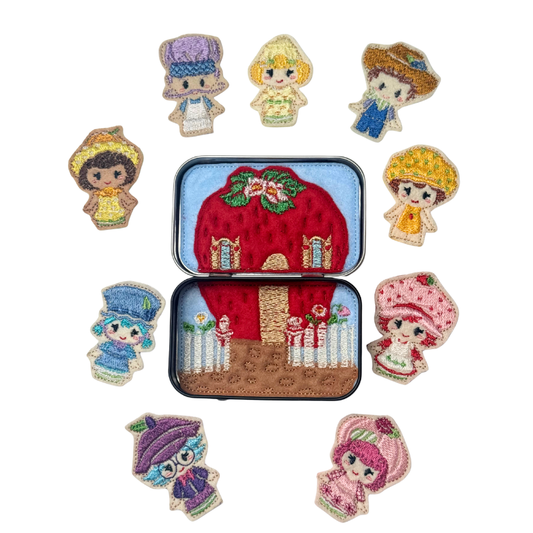 Set of embroidered characters around a tin with a red house design on a white background