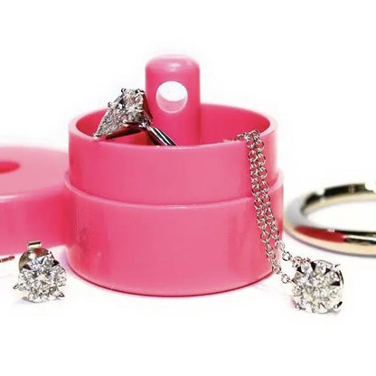 Pink jewelry box with diamond earrings and a necklace on a white background