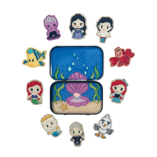 Set of under the sea-themed pins with a tin container on a white background
