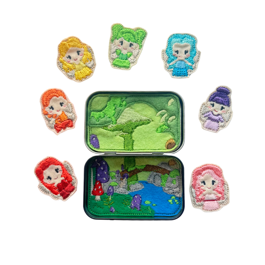 Colorful embroidered patches of fairy tale characters around a small tin with embroidered design.