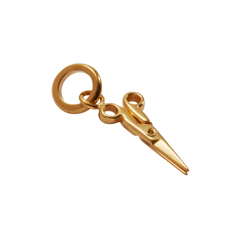 Gold scissors charm on a white background
